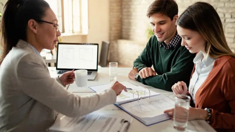 Conseillère présentant les options d'un prêt de 750 à un couple lors d'une consultation financière