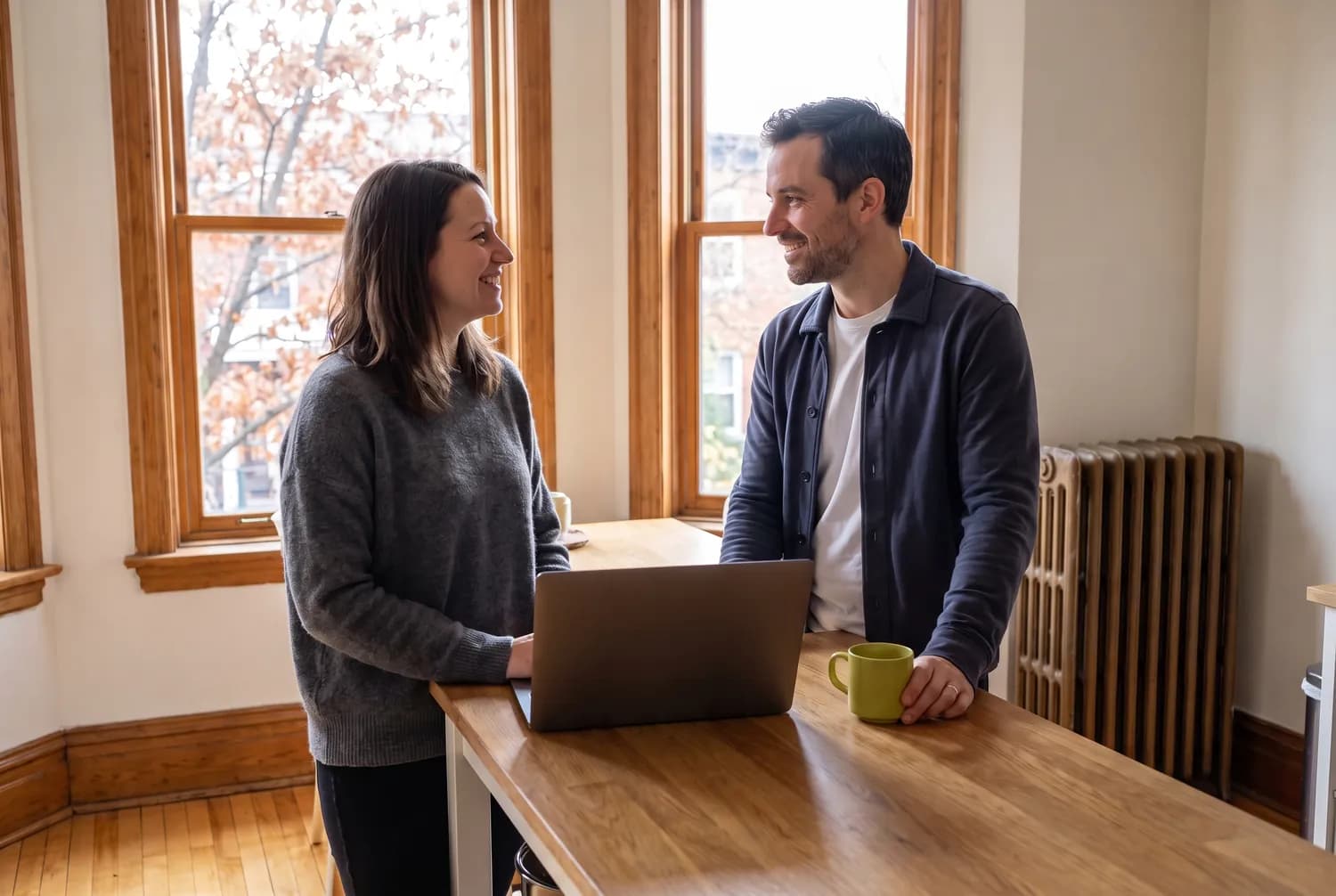 Un couple souriant devant un ordinateur portable