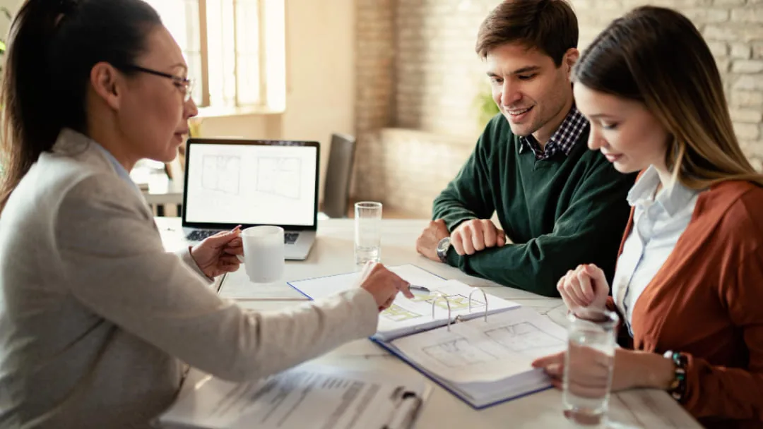 Conseillère présentant les options d'un prêt de 750 à un couple lors d'une consultation financière